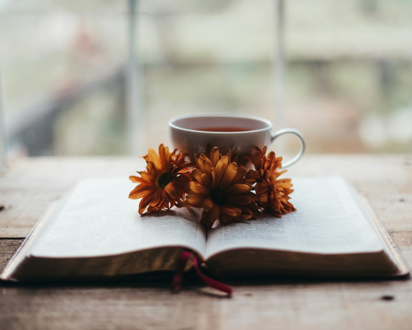 Open Bible with tea and flowers